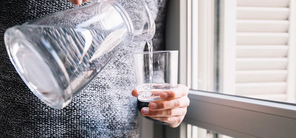 vand skænkes fra kande til glas