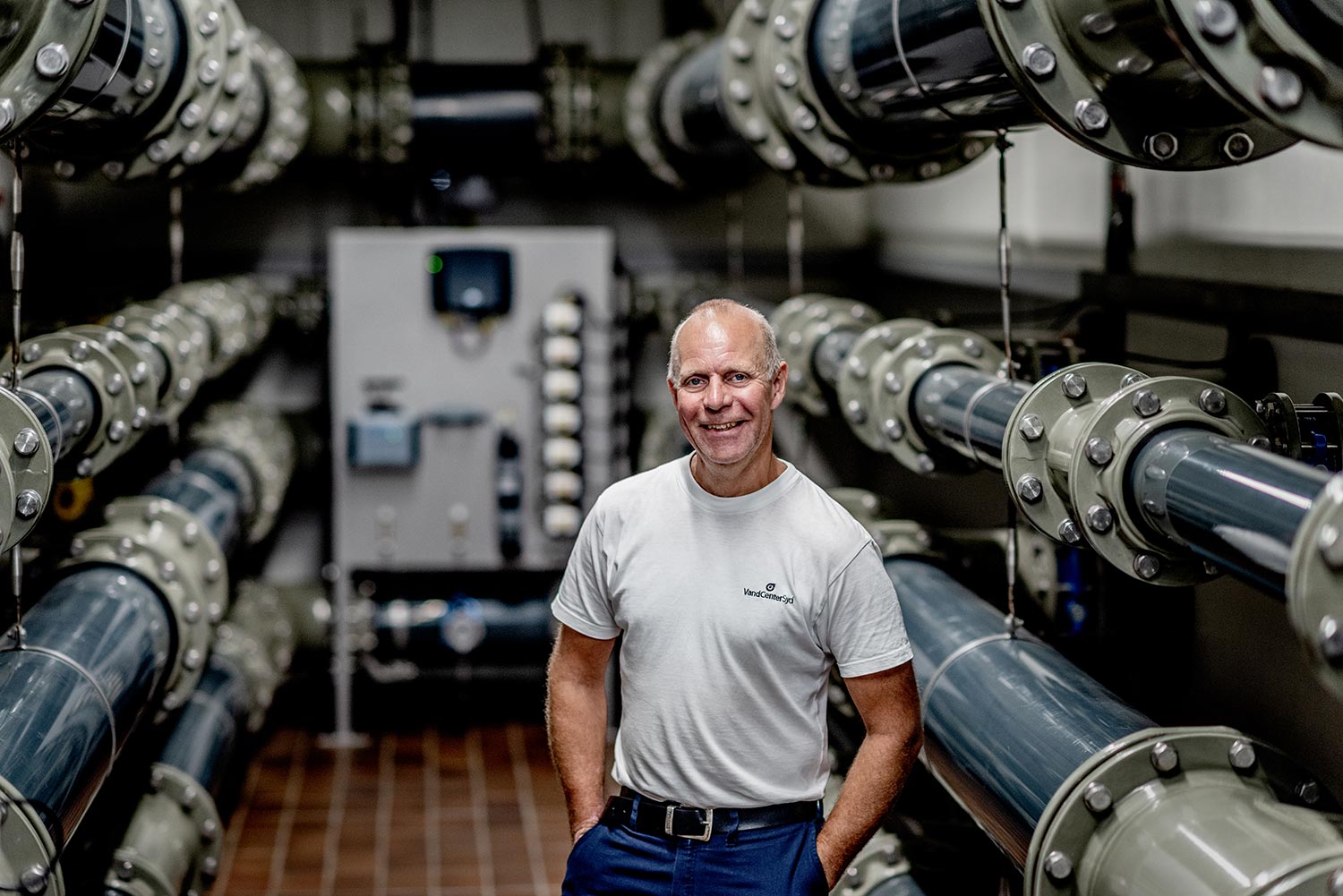 Smilende mand i lokale med store rør