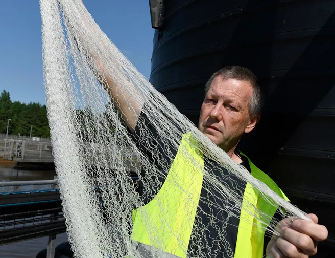 Mand i arbejdstøj fremviser tynde membraner til biologisk rensning af spildevand