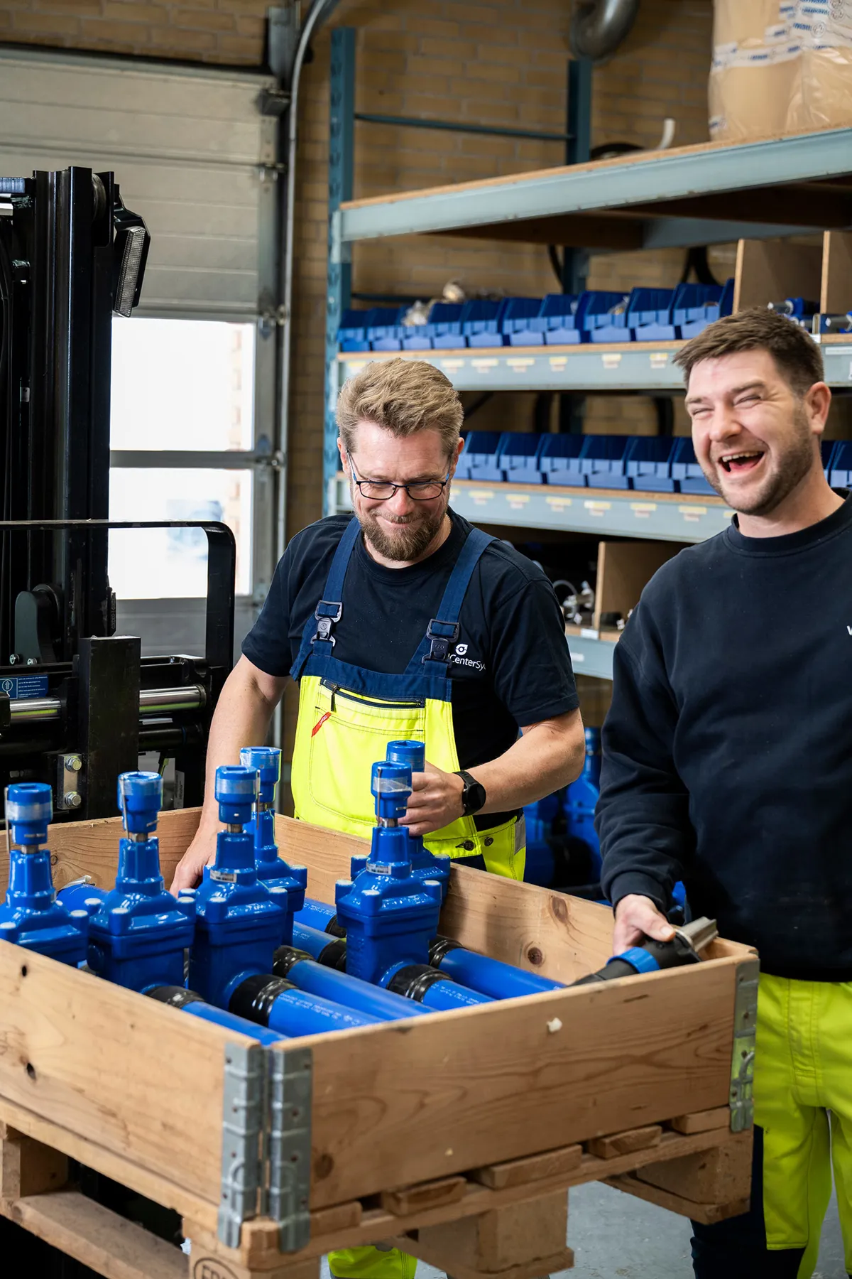 To VandCenter Syd medarbejdere ses smilende på jobbet.