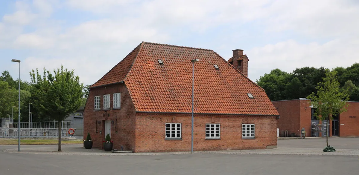 Foto af besøgscentret på Ejby Mølle renseanlæg, en rød murstensbygning med tegltag.