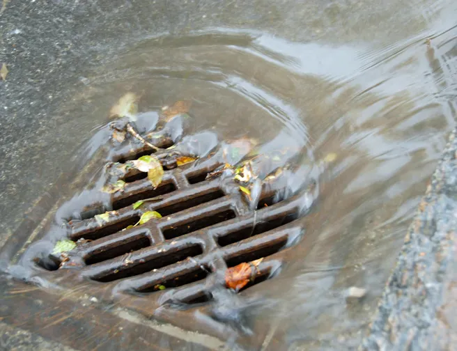 Vand skyller ned i en vejrist i kraftigt regnvejr