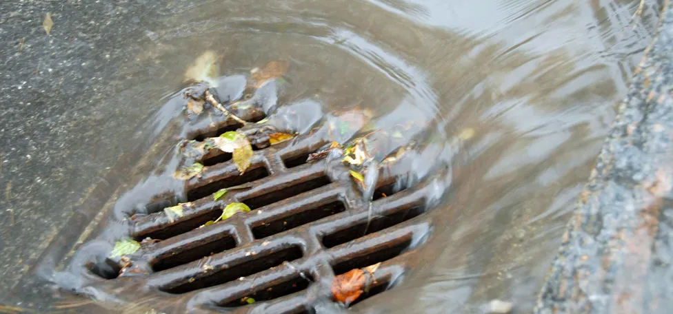 Vand skyller ned i en vejrist i kraftigt regnvejr