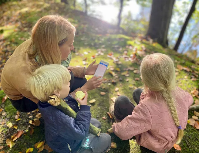 Kvinde og to små børn på natureventyr i skoven